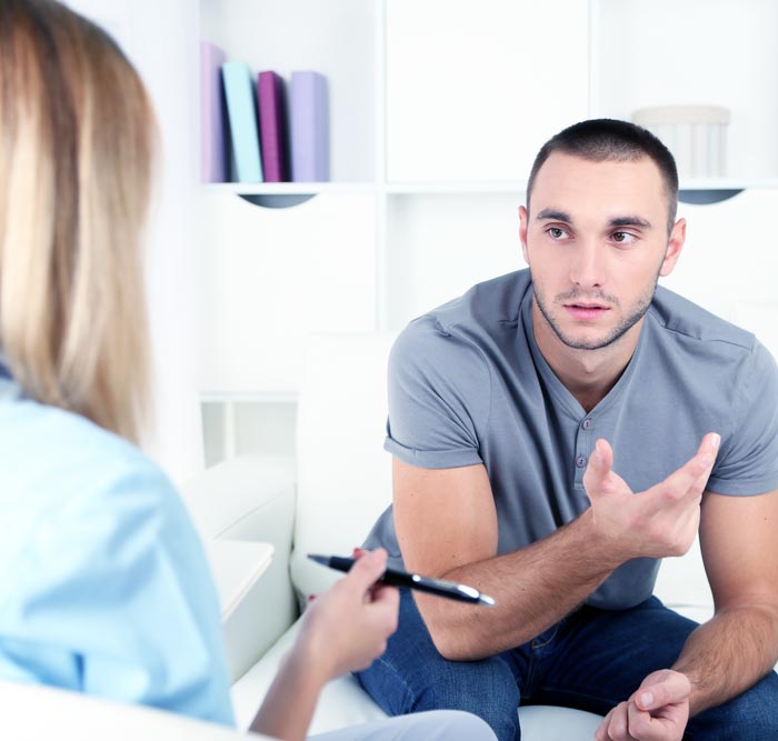a young man talking to a psychologist during a dual diagnosis treatment