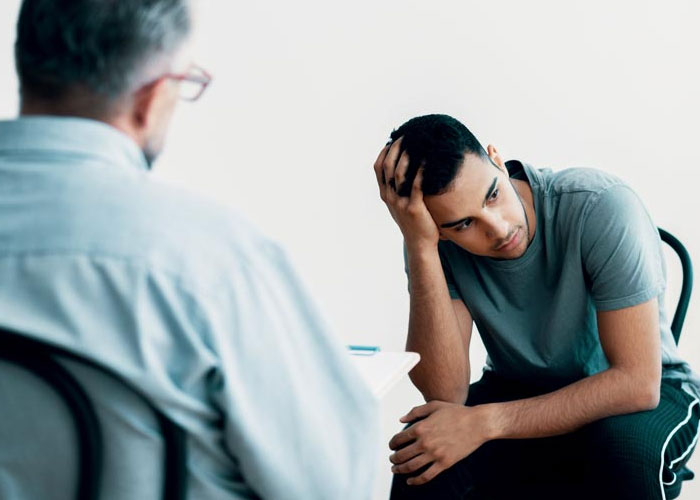 a young man with a psychologist at an alcohol rehab